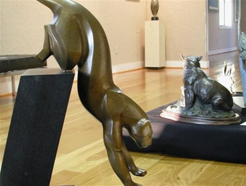 A statue of a cat is on display in a museum