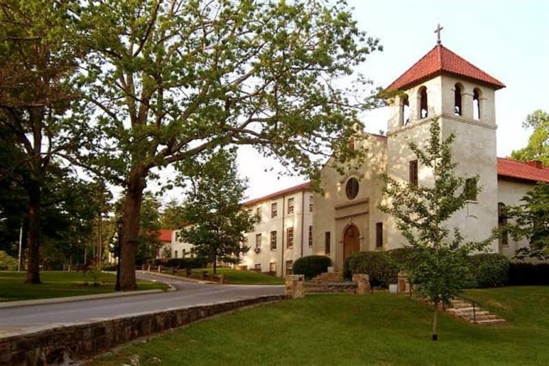 A large white building with a red roof and a bell tower