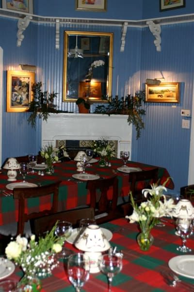A dining room table with plates glasses and flowers on it