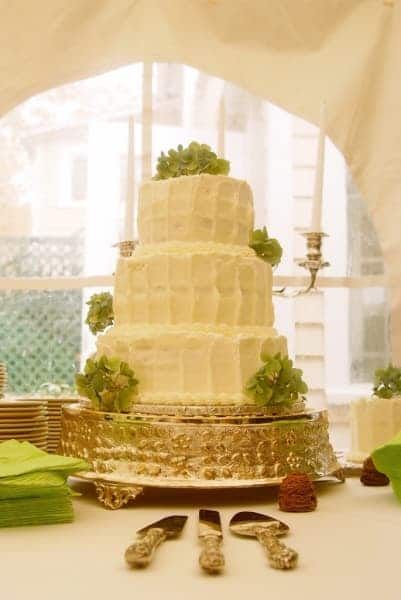 A wedding cake is sitting on a table under a tent