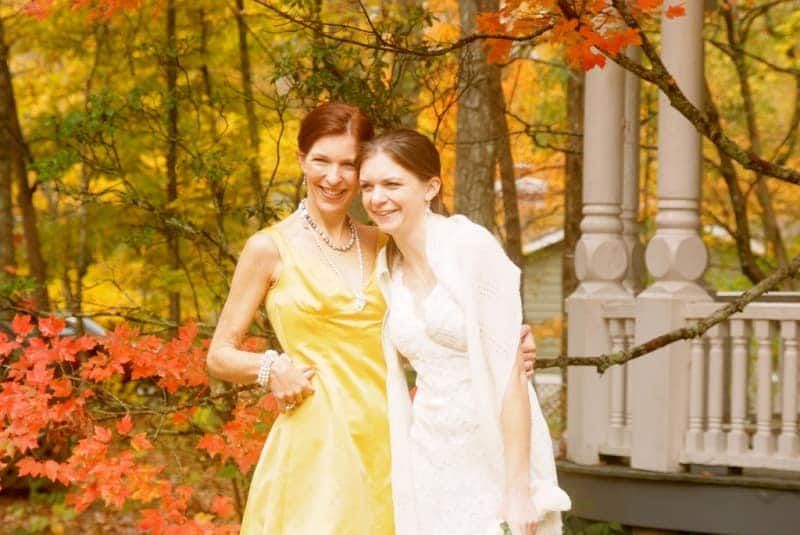 Two women in yellow and white dresses are posing for a picture.