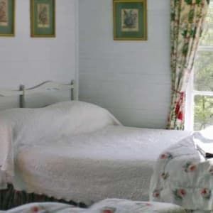 A living room with a couch , chairs , tables and a fireplace.