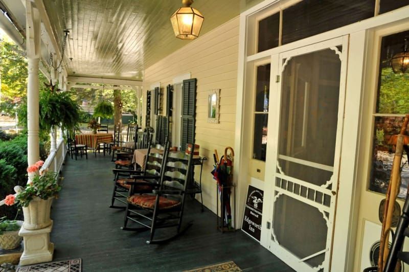 A porch with rocking chairs and a screen door