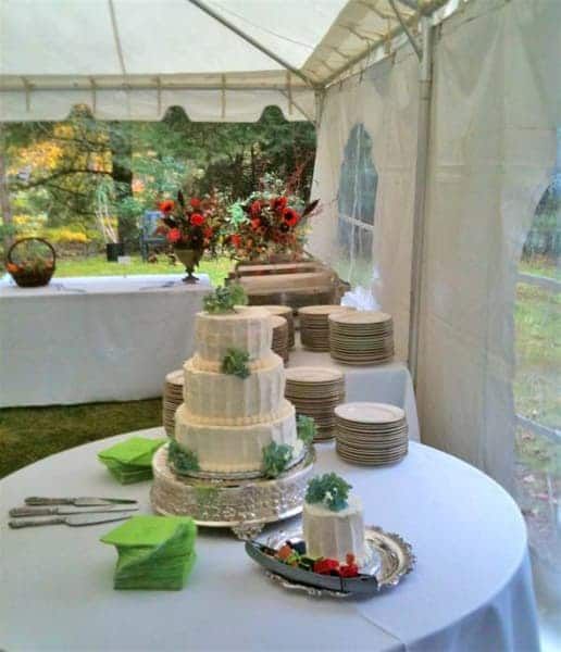 A wedding cake is on a table under a tent