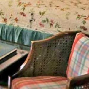 A bedroom with a bed , nightstand , lamp and rug