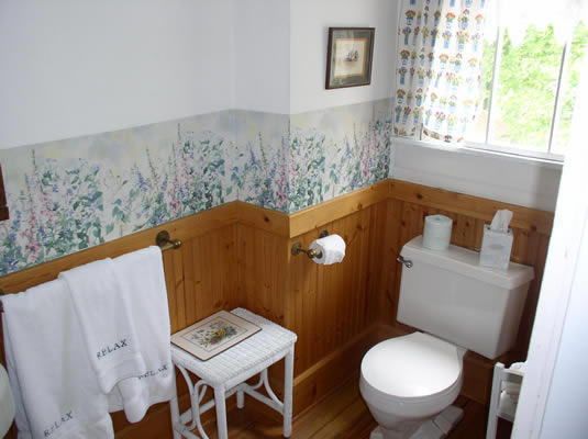 A bathroom with a toilet and a stool