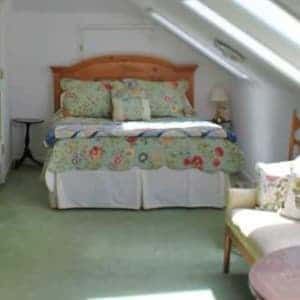 A bedroom with a four poster bed and a rug.