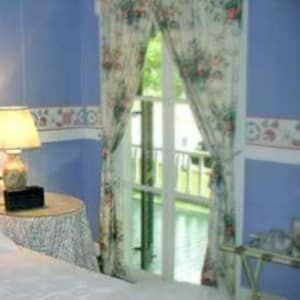 A bedroom with a bed , nightstand , lamp and rug