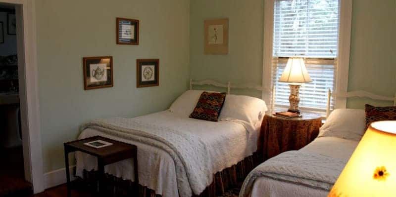 A bedroom with two twin beds and a lamp