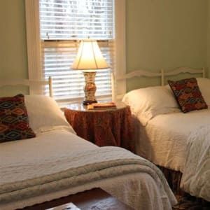 A living room with a couch , chairs , tables and a fireplace.