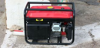Red and black portable generator on concrete.