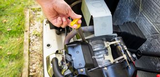 A person's hand pulling the starter of a generator.