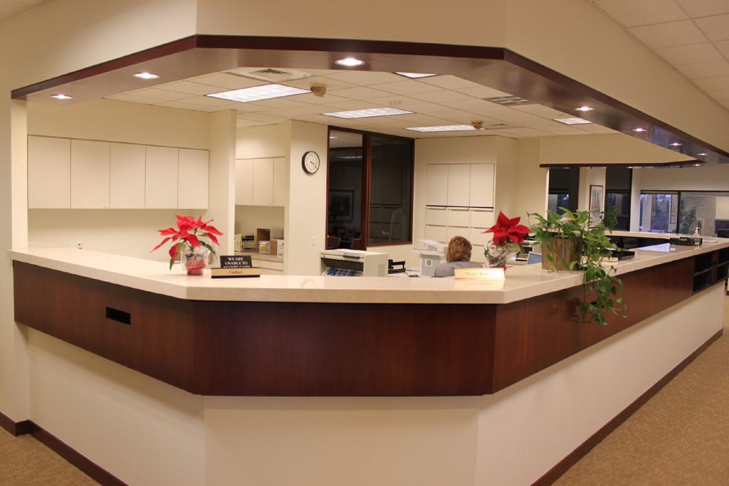 A reception desk with a clock on the wall above it