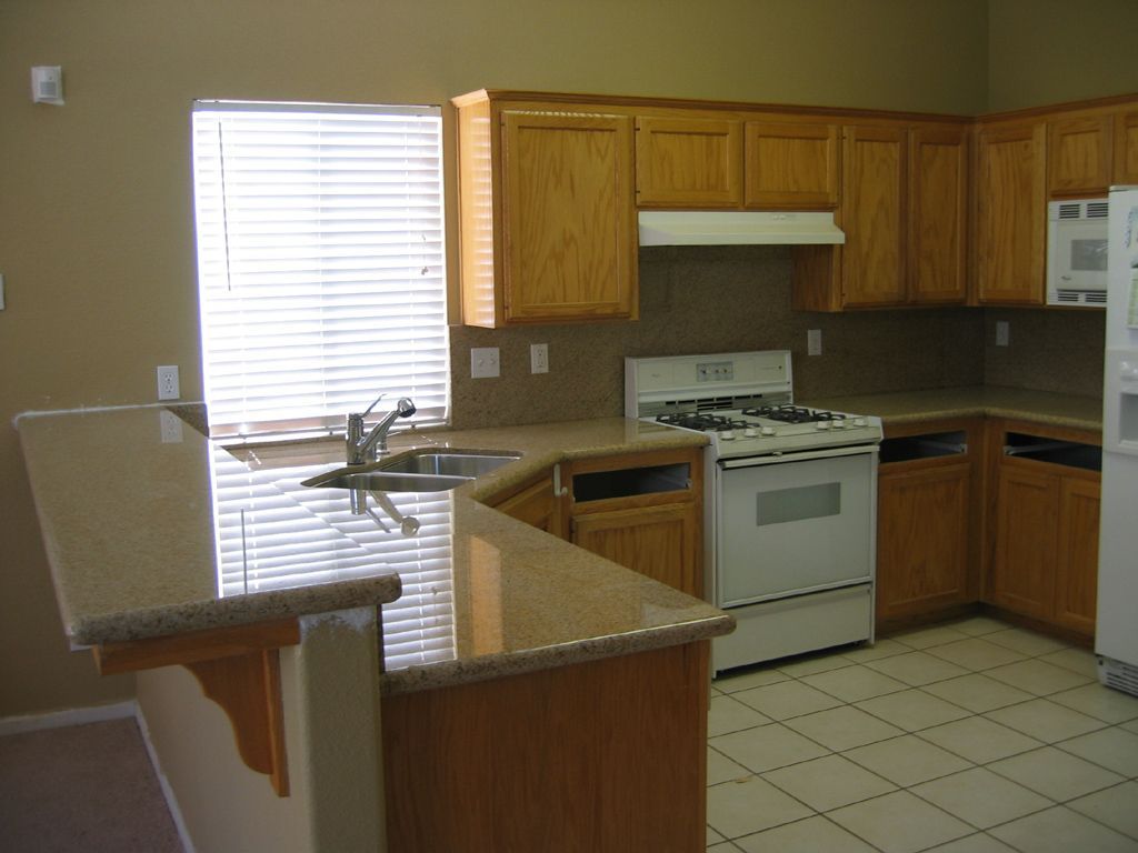 A kitchen with a stove a sink and a microwave