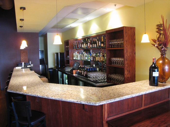 There is a marble counter top in the foreground and a bathroom in the background.