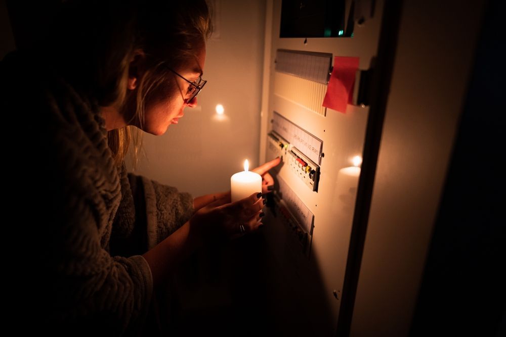 A woman is lighting a candle in a dark room.