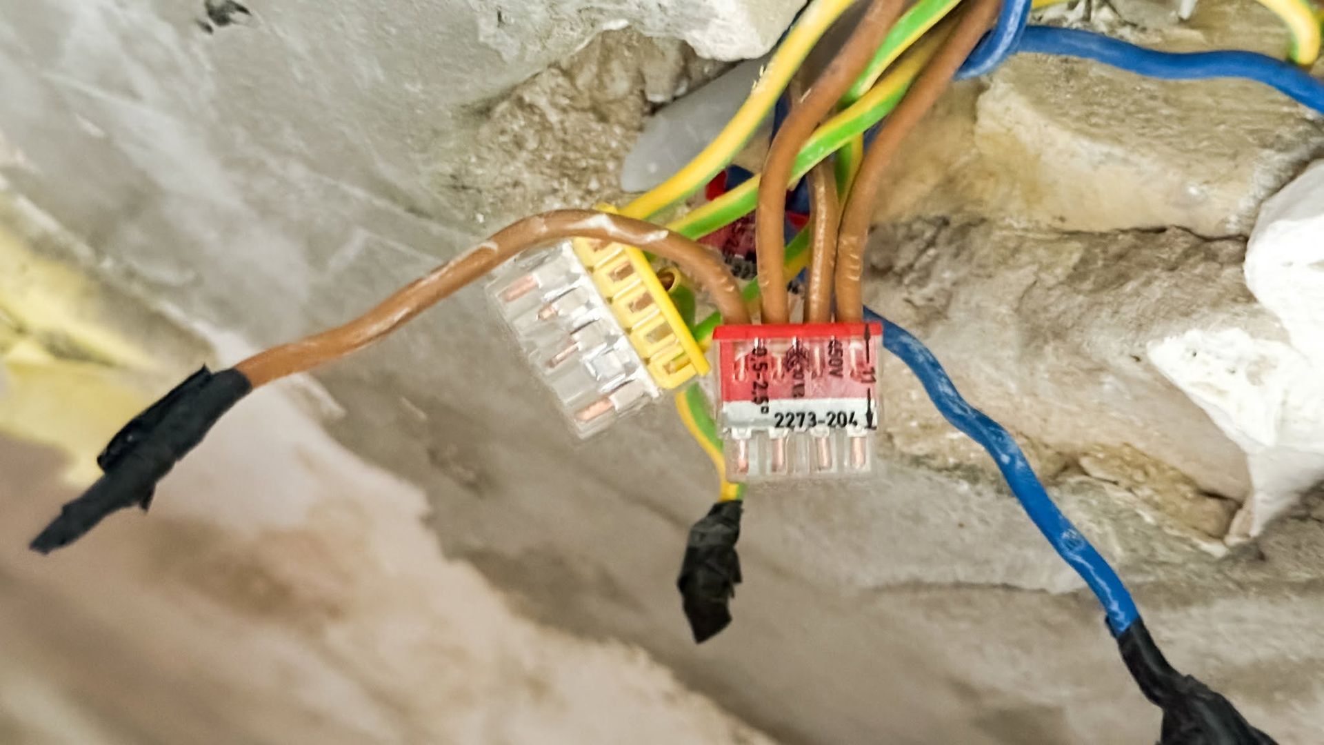 Electrical wires with connectors and taped ends exposed in a wall cavity