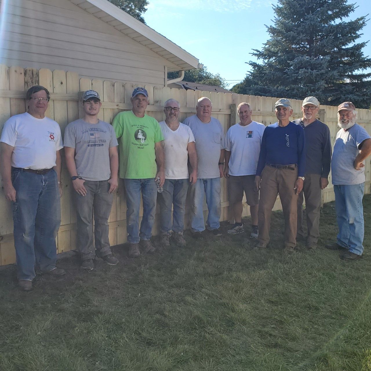 A group of men standing in front of a brick wall