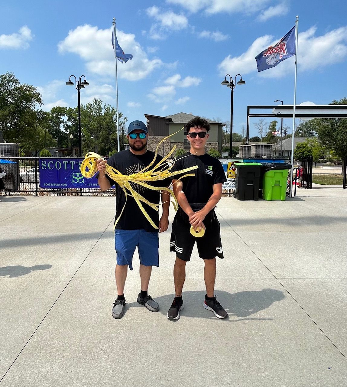 Two men standing in front of a sign holding raffle tickets