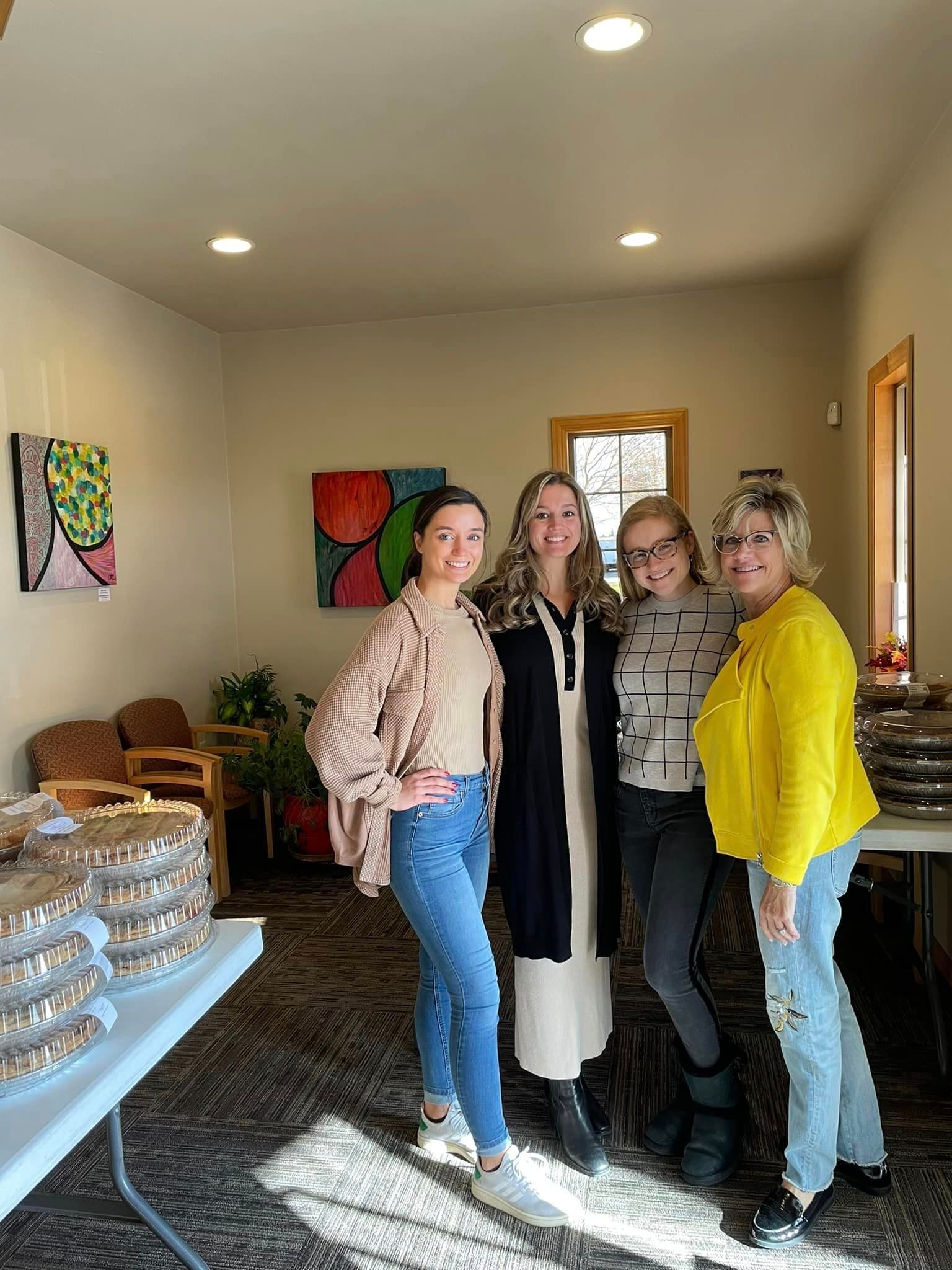 A group of women are standing next to each other in a room.