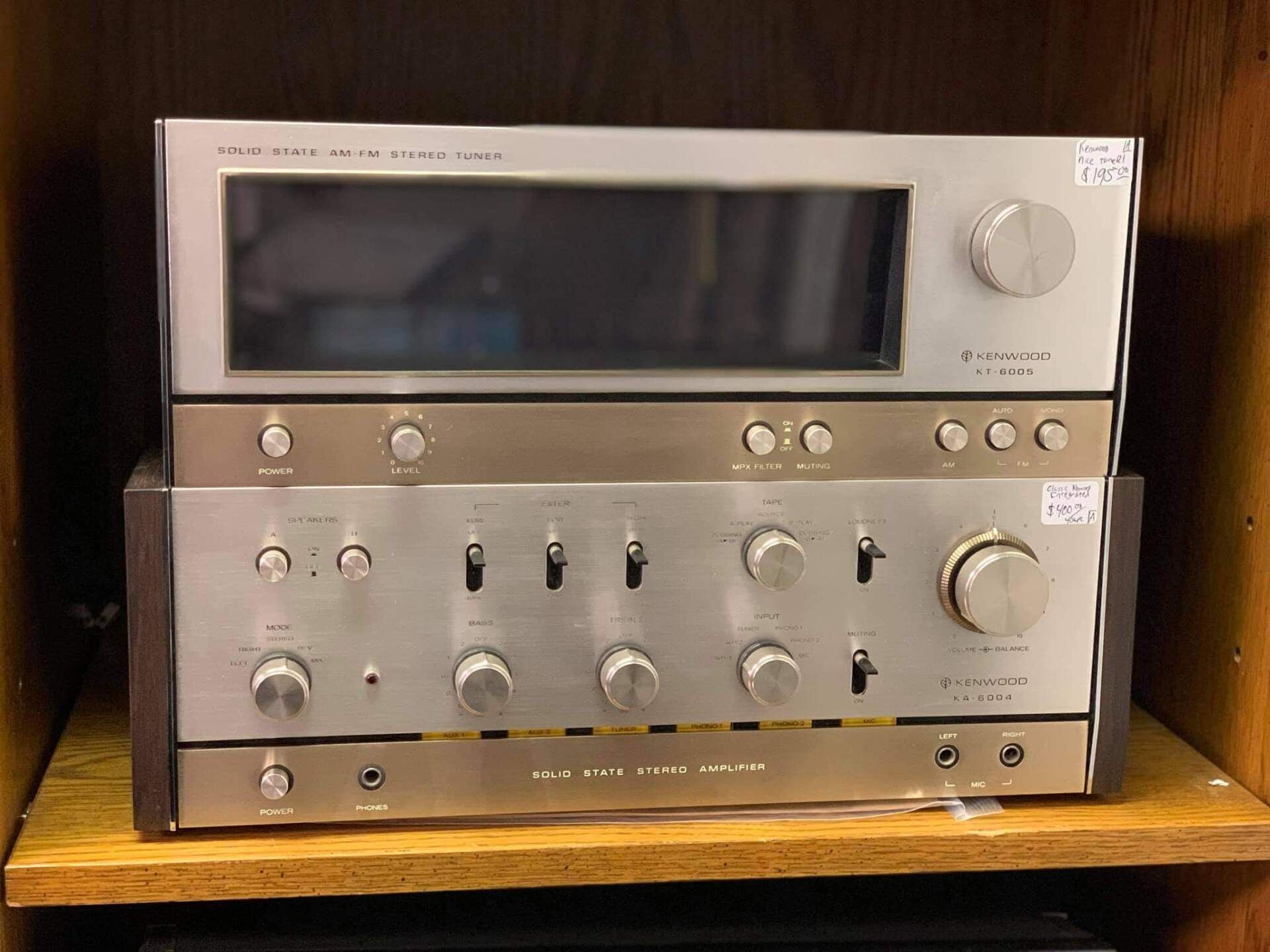 A stereo system is sitting on a wooden shelf.