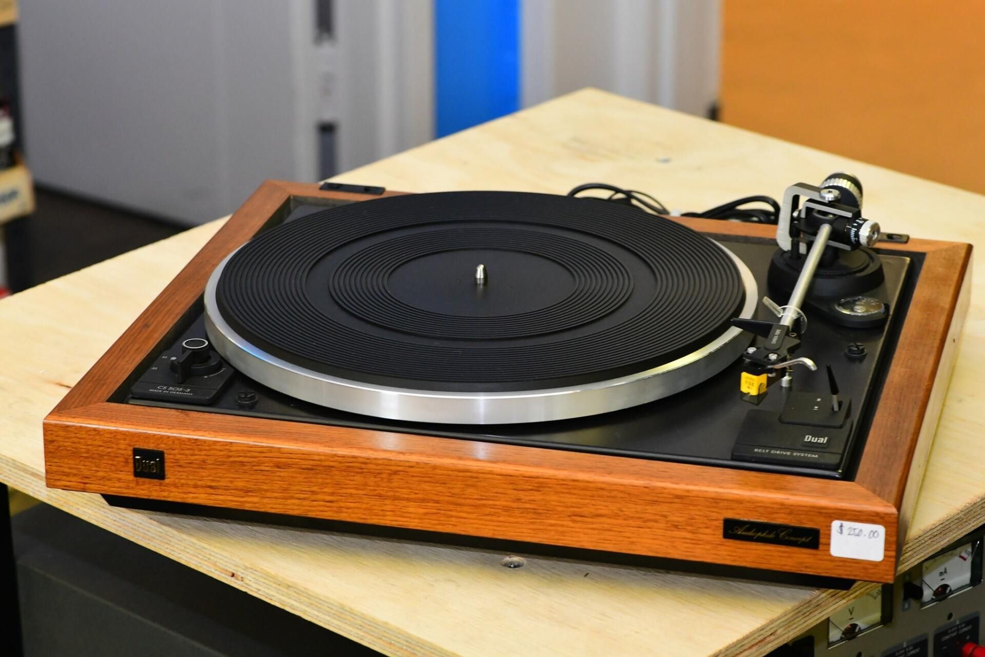 A record player is sitting on a wooden table.
