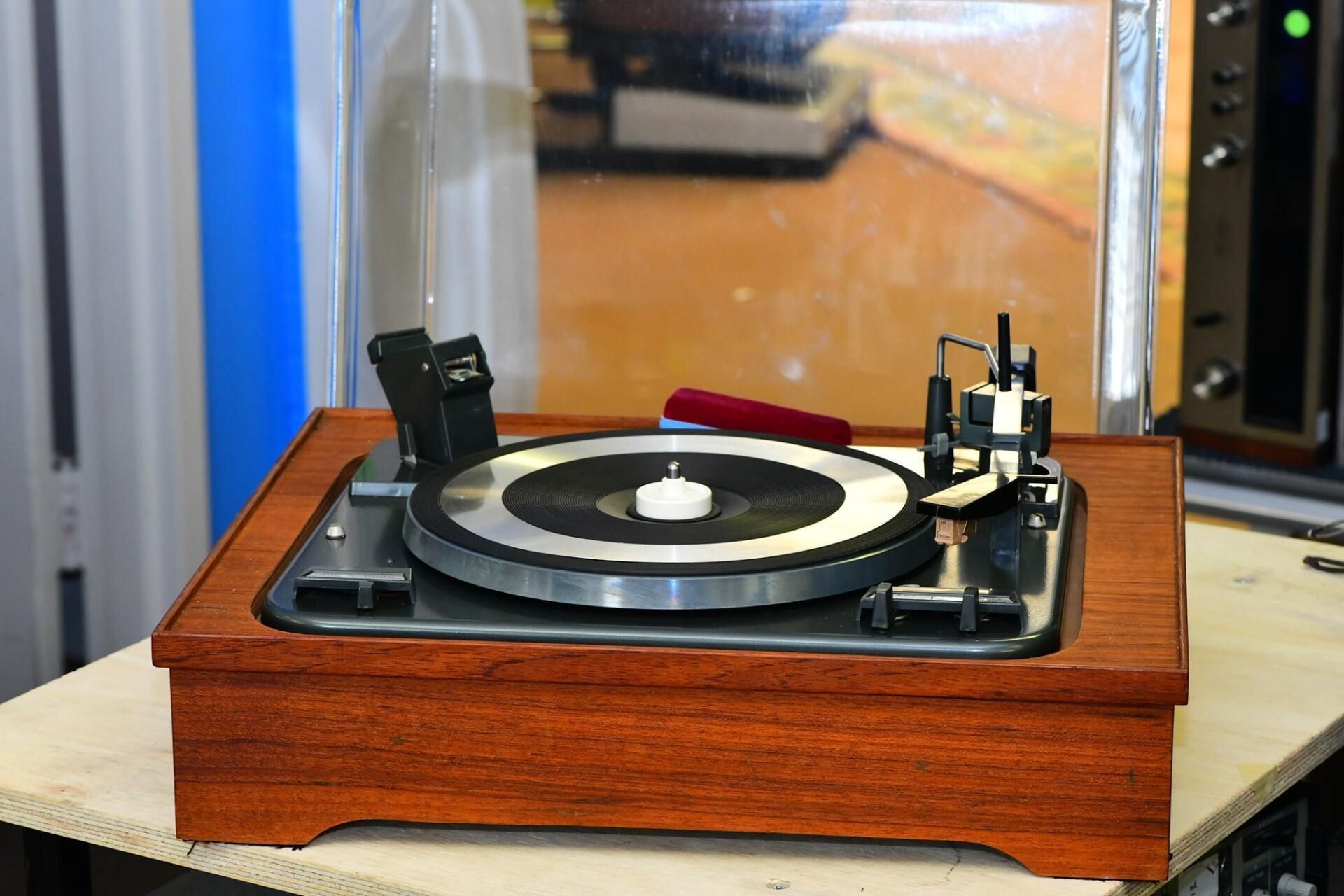 A record player is sitting on a wooden table.