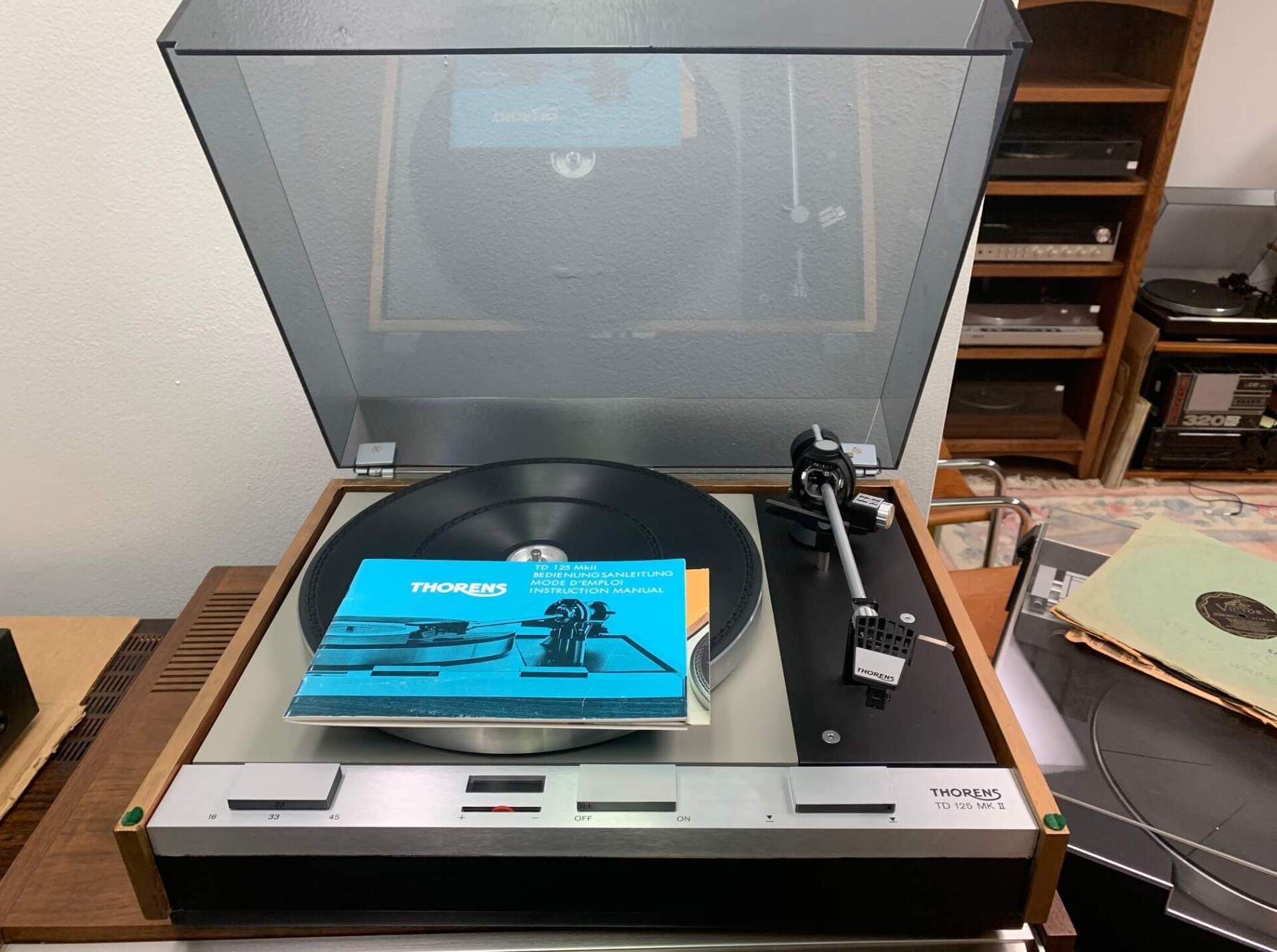 A record player with the lid open and a record on it.