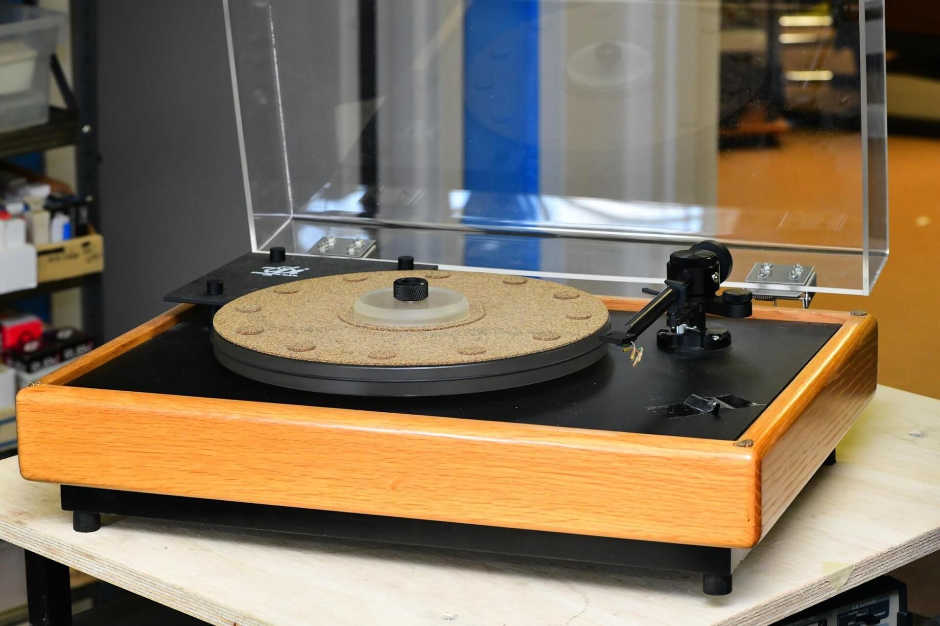 A record player with a clear cover is sitting on a table
