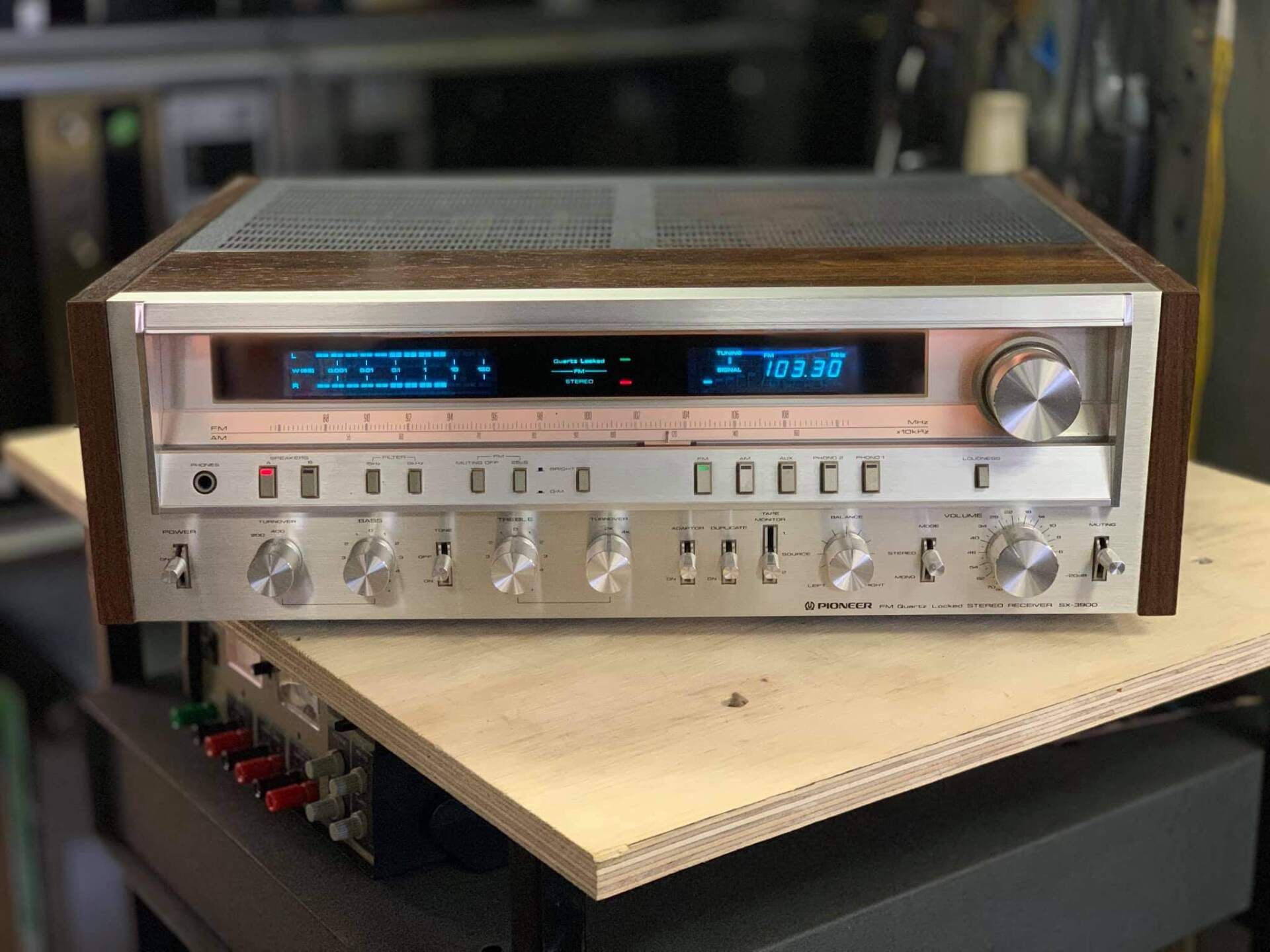A stereo receiver is sitting on top of a wooden table.