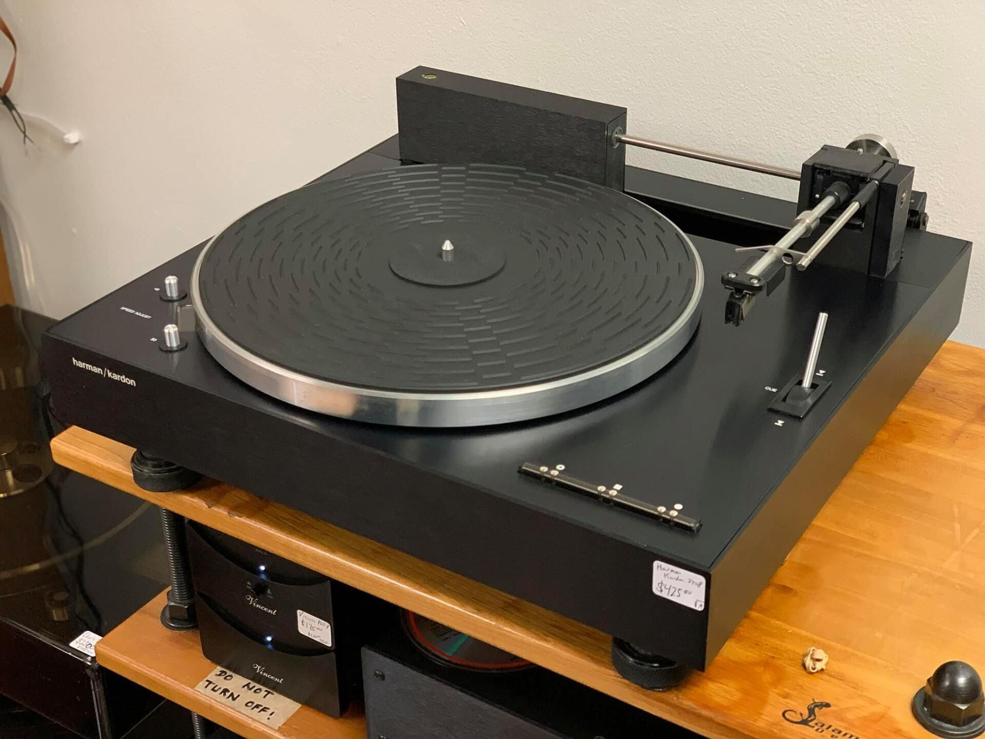 A record player is sitting on top of a wooden table.