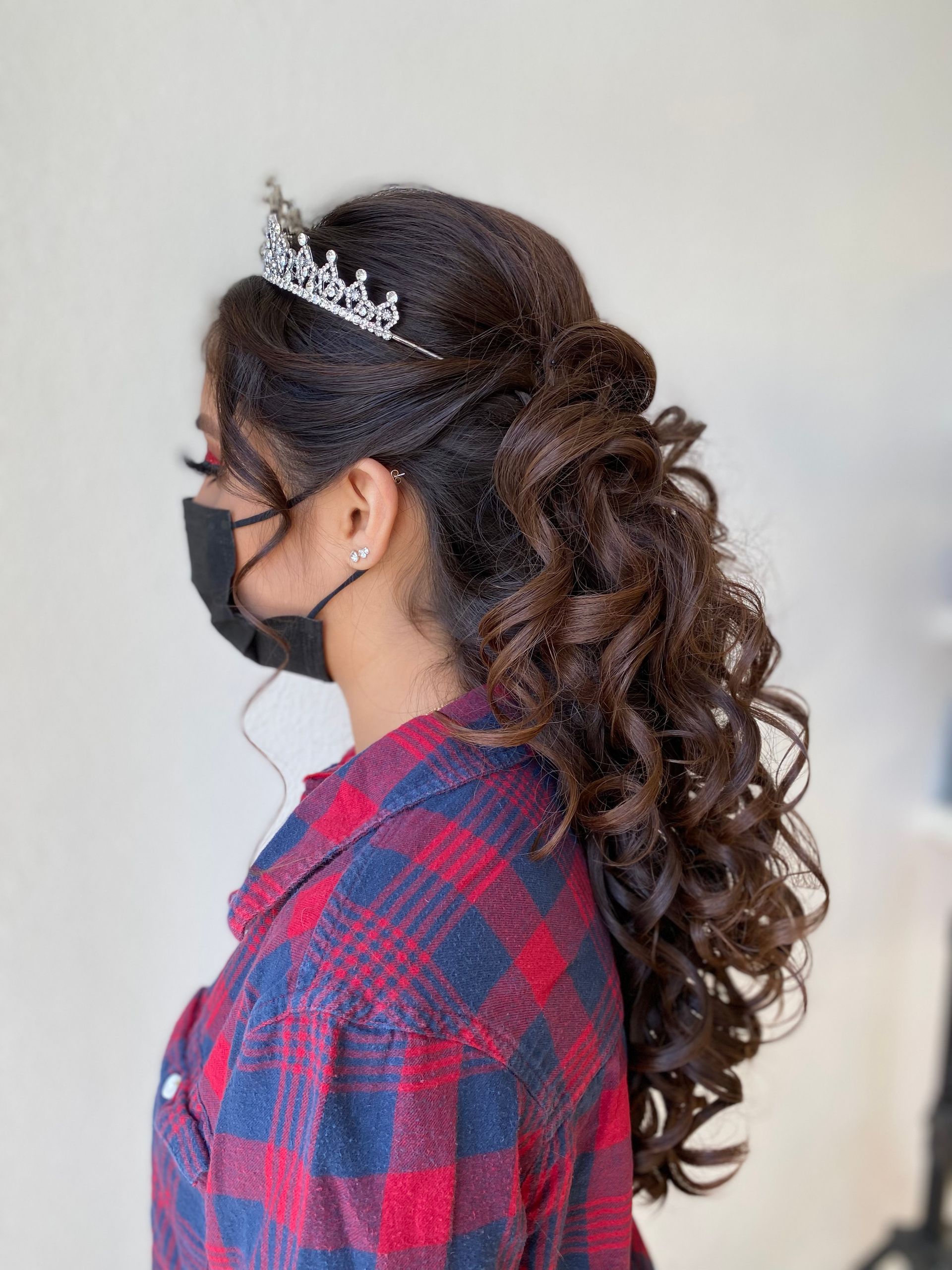 A woman wearing a mask and a tiara on her head.