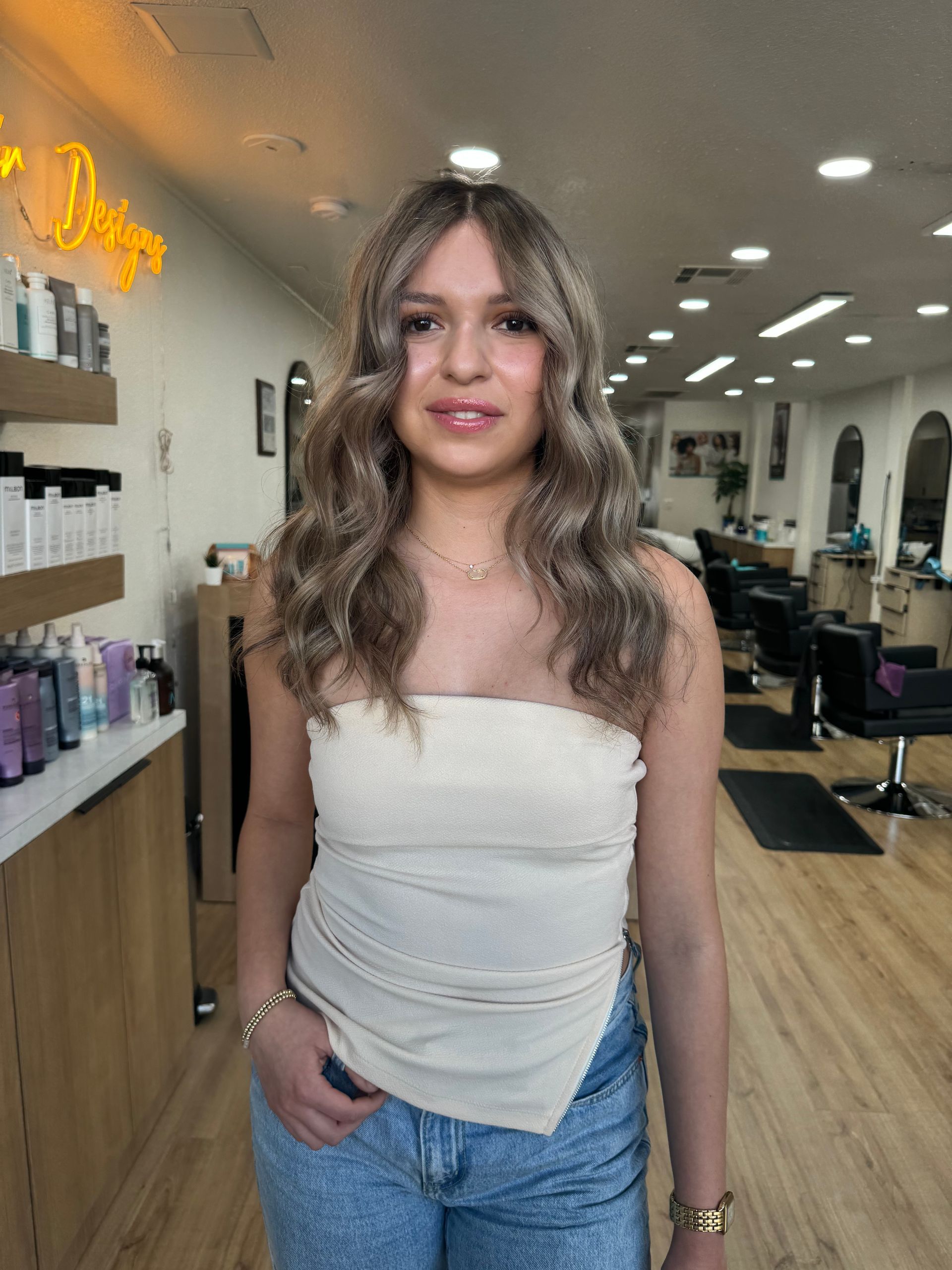 A woman is standing in a salon with her hands in her pockets.