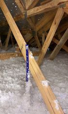 A wooden structure with insulation in the attic of a house.