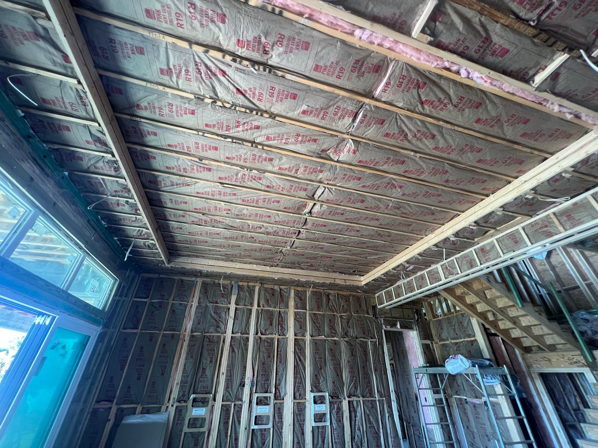 A room under construction with a ceiling that is covered in insulation.