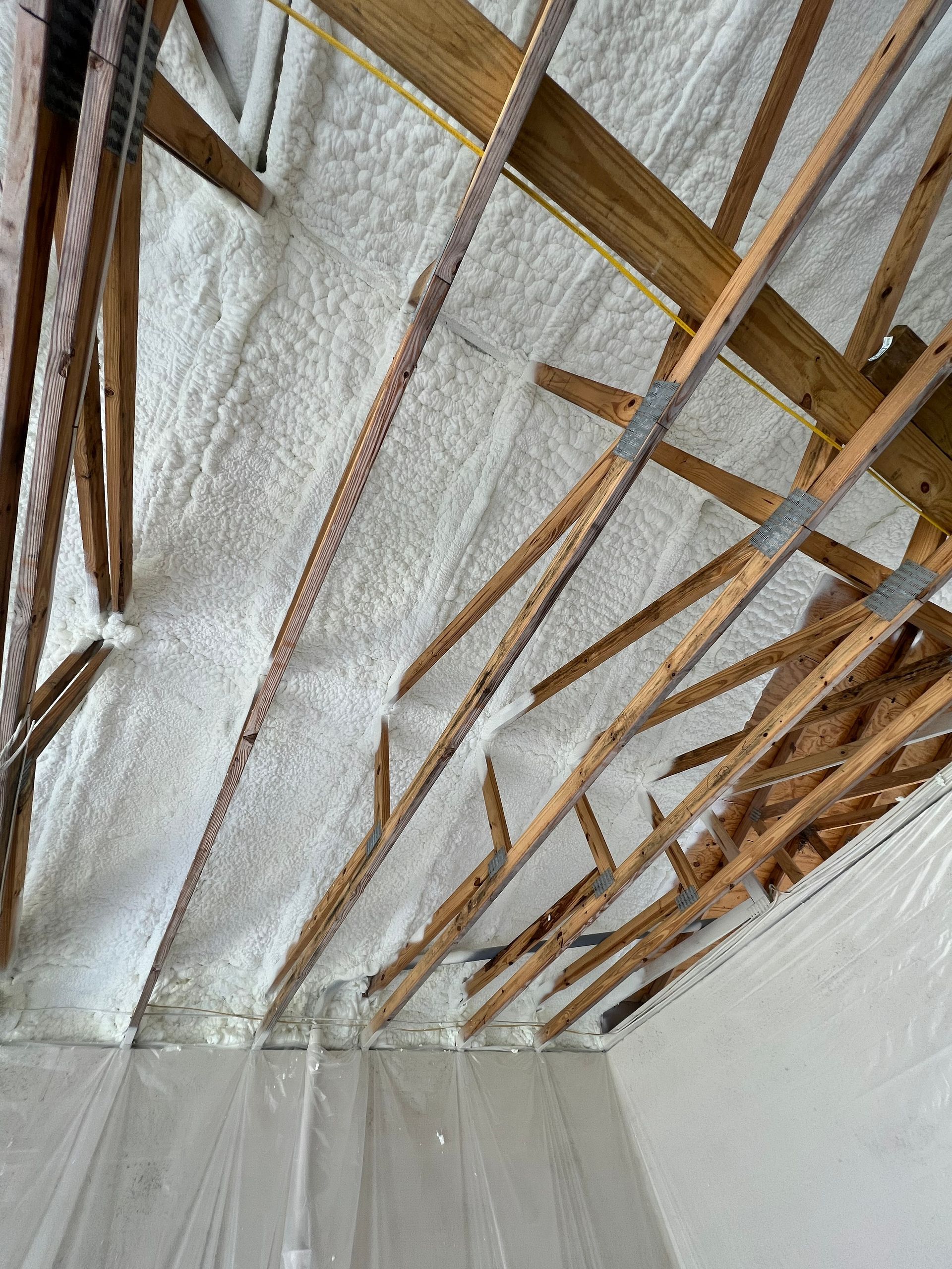 A room with a ceiling that is covered in foam and wooden beams.