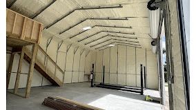 The inside of a garage with a staircase and a lot of insulation.