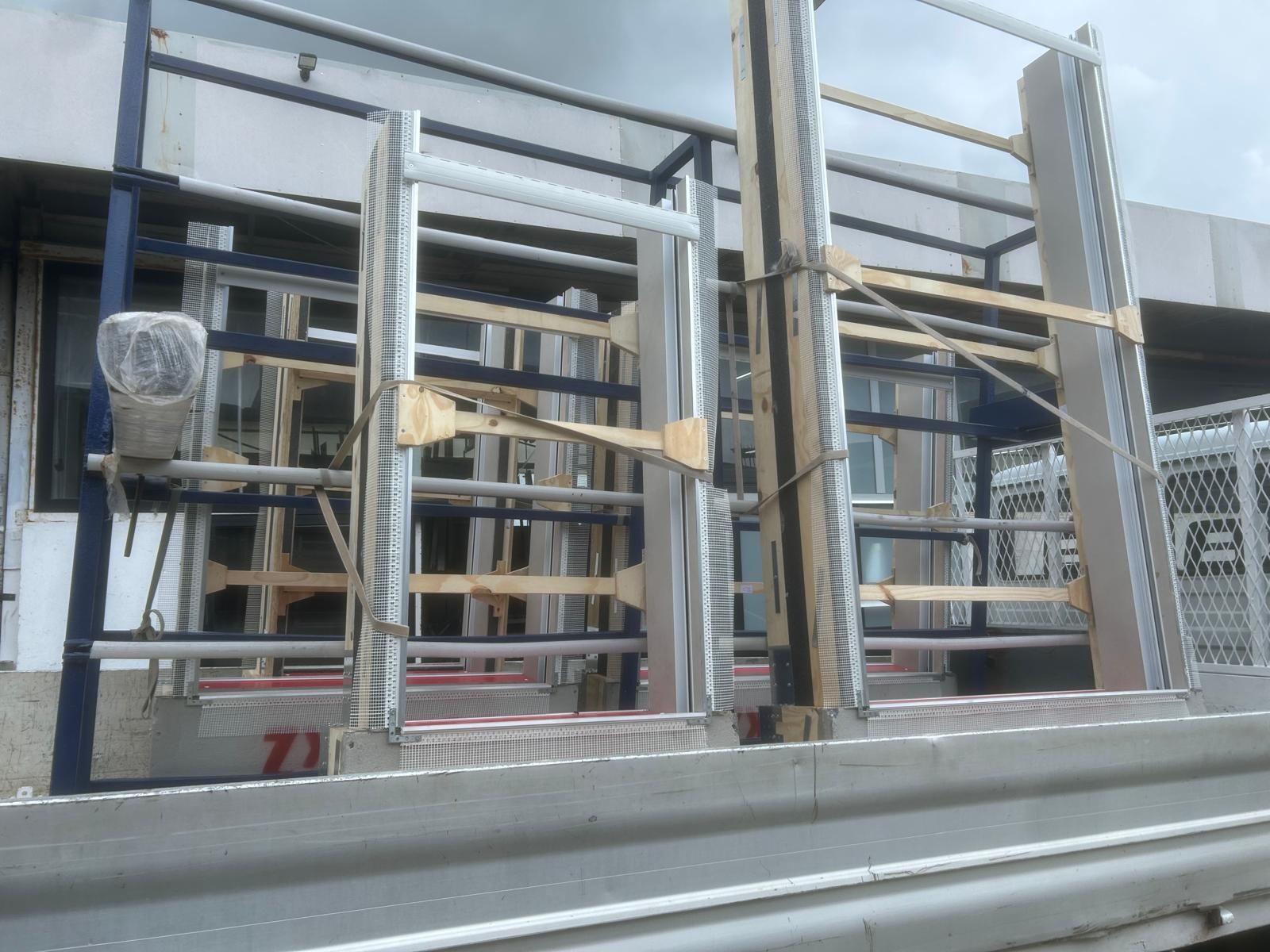 Soggiorno luminoso e vuoto con pavimenti in legno, camino e ampie finestre che lasciano entrare luce naturale.