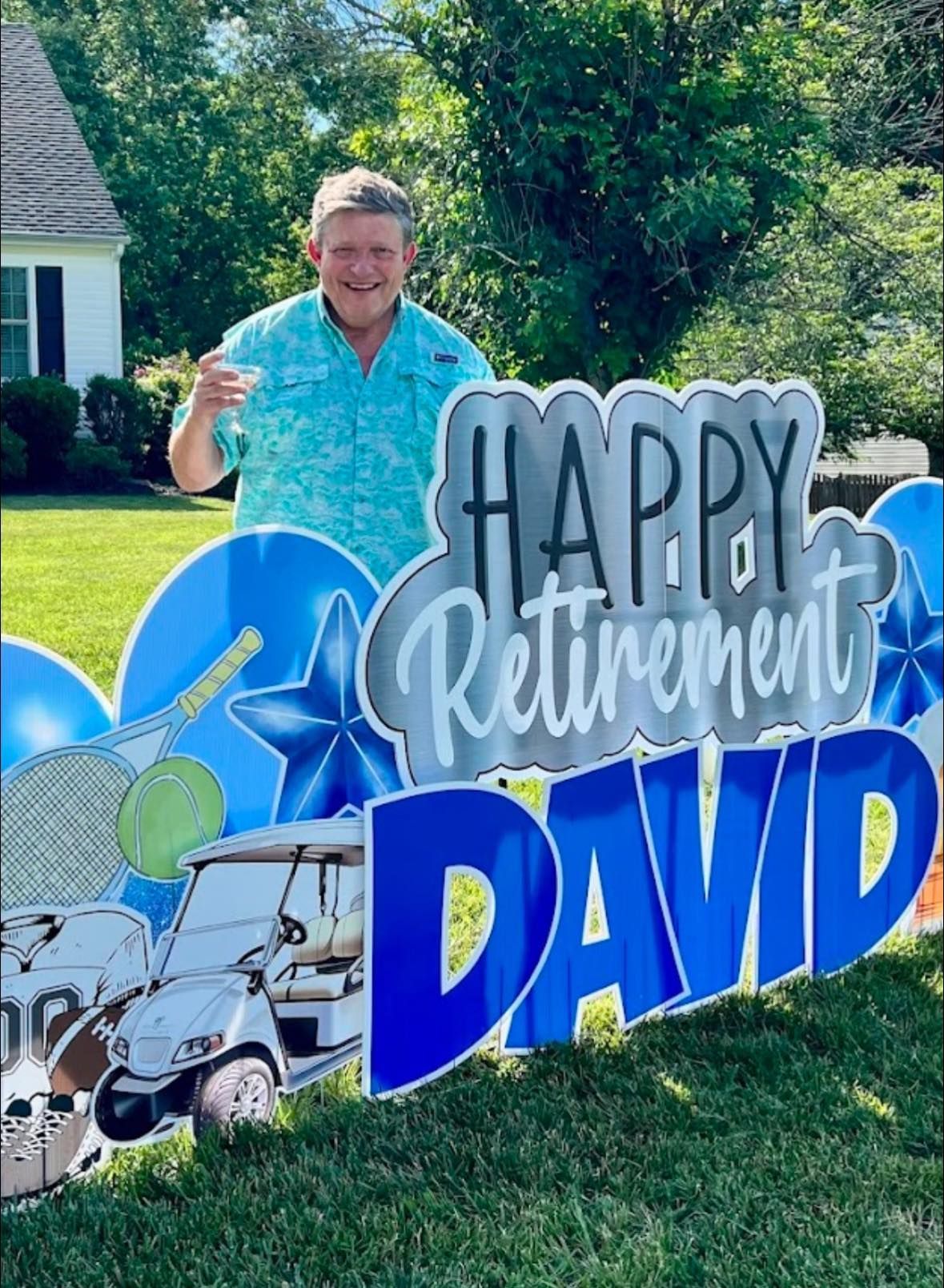 A man is standing in front of a sign that says `` happy retirement david ''.