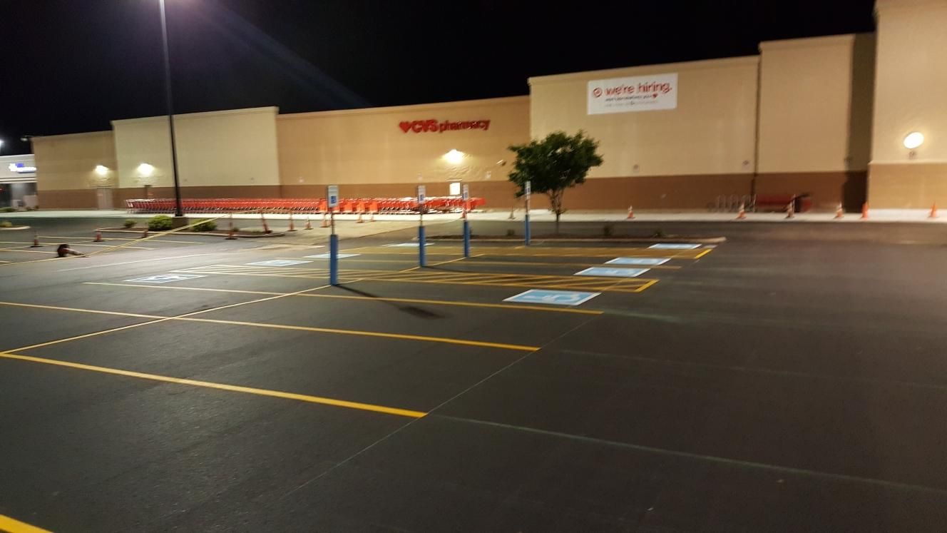 An empty parking lot in front of a walgreens store at night.