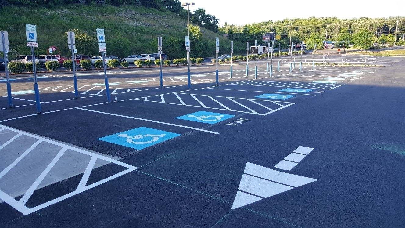 A parking lot with handicapped parking spots and an arrow pointing to the right.