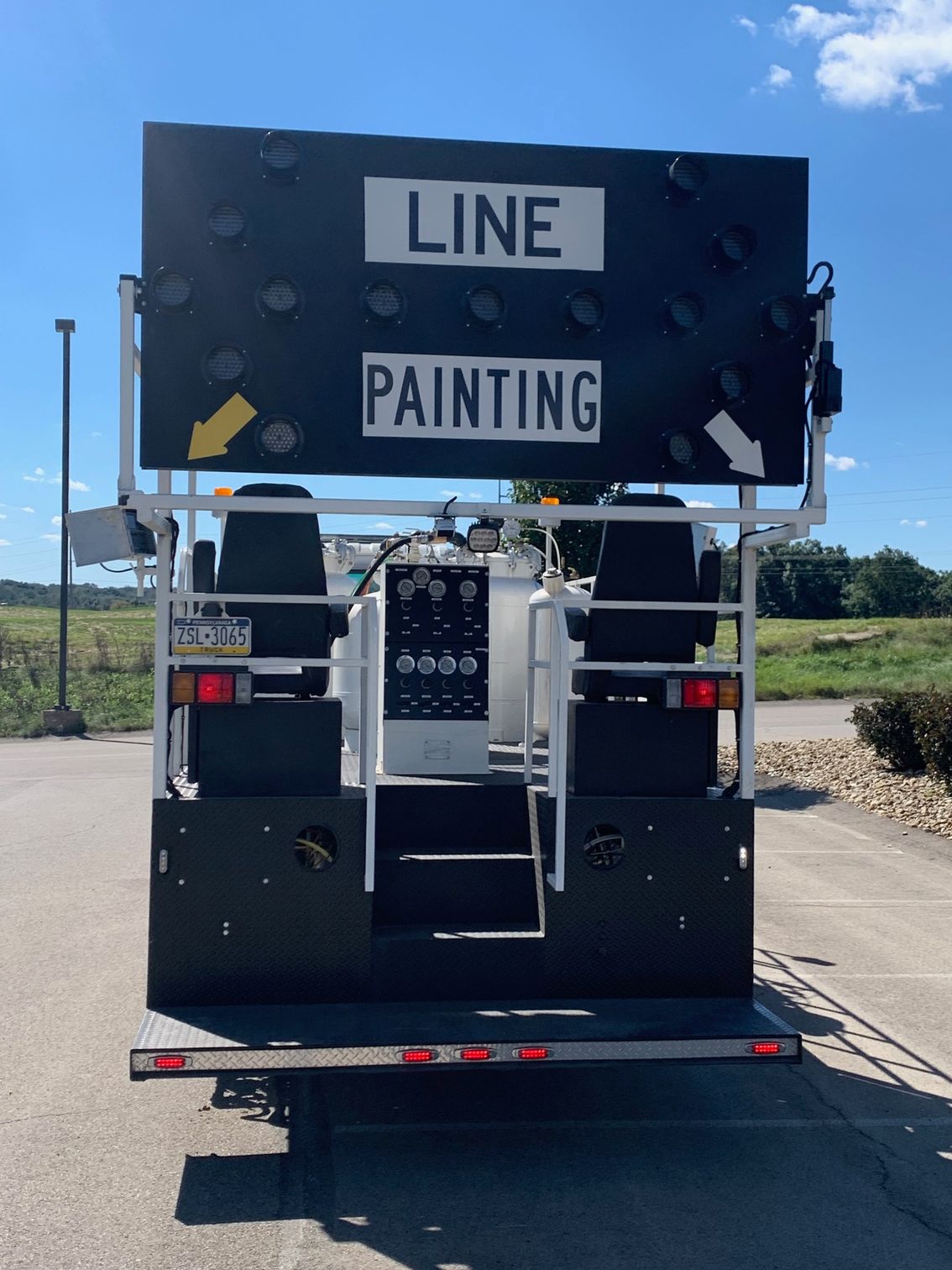 A truck with a sign on the back that says line painting