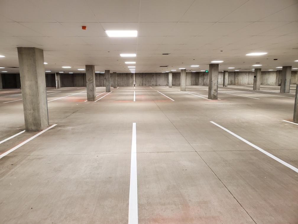 An empty parking garage with white lines on the floor.