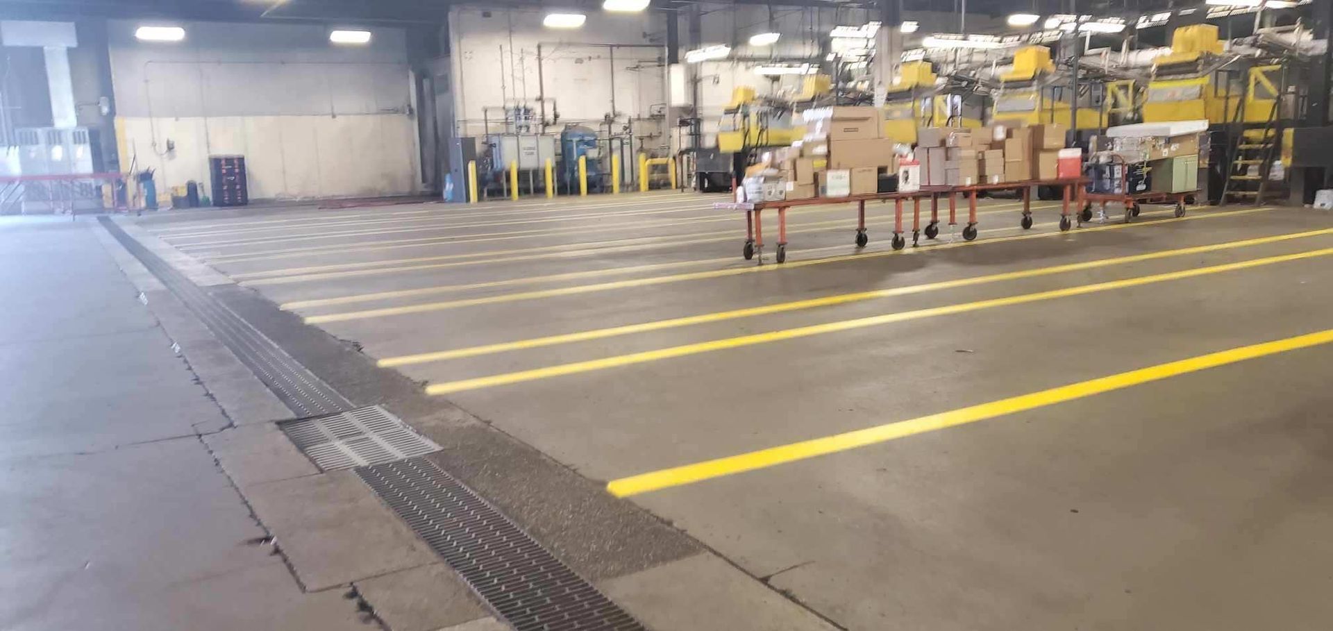 A large warehouse with yellow lines on the floor.