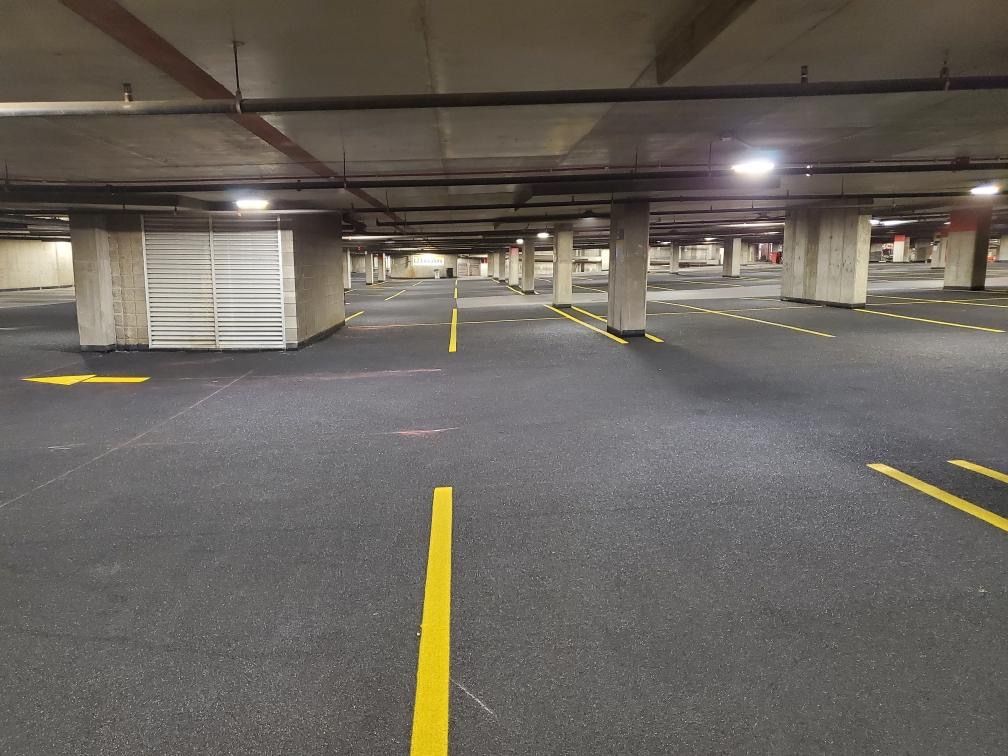 An empty parking garage with yellow lines and an arrow pointing to the right