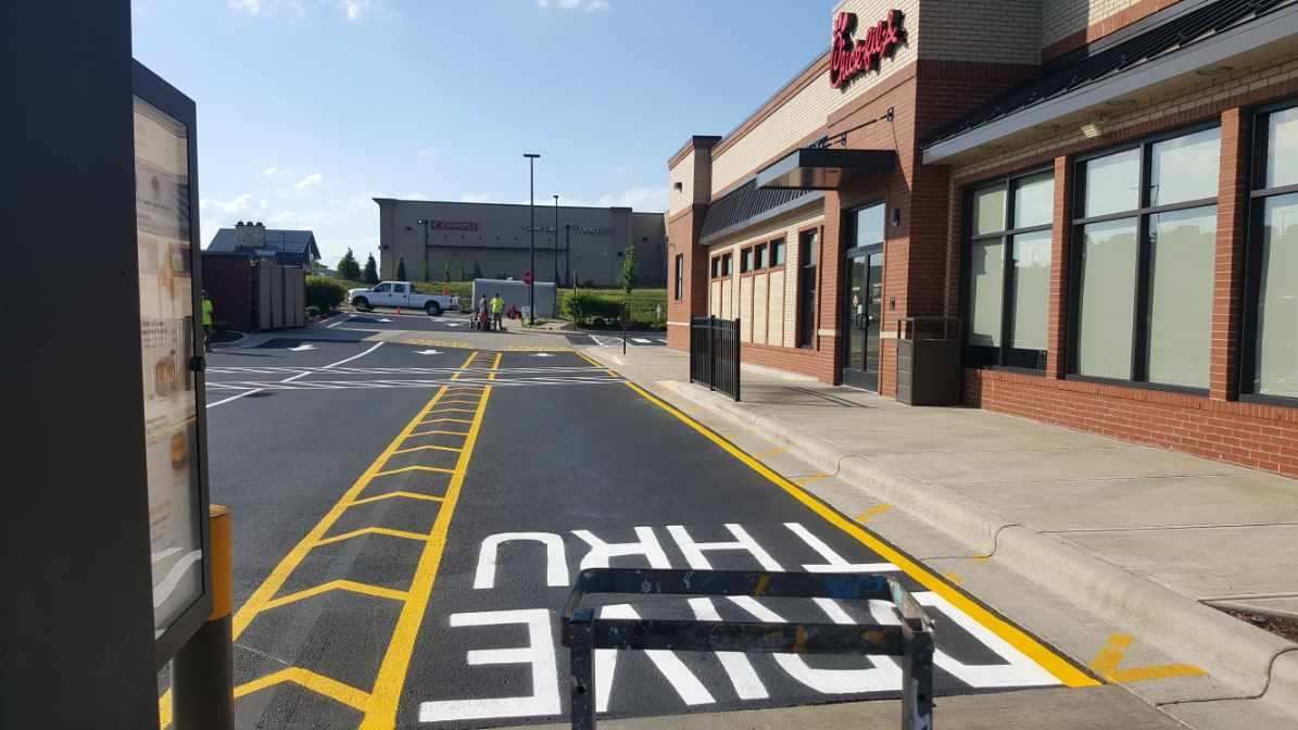 A drive thru sign is painted on the side of the road