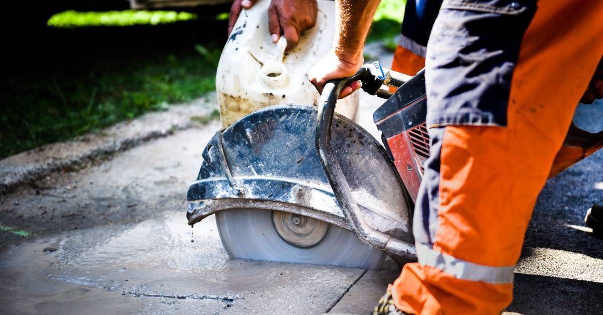 A construction worker is working on a machine on a construction site.