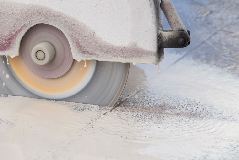 A circular saw is cutting a piece of concrete.