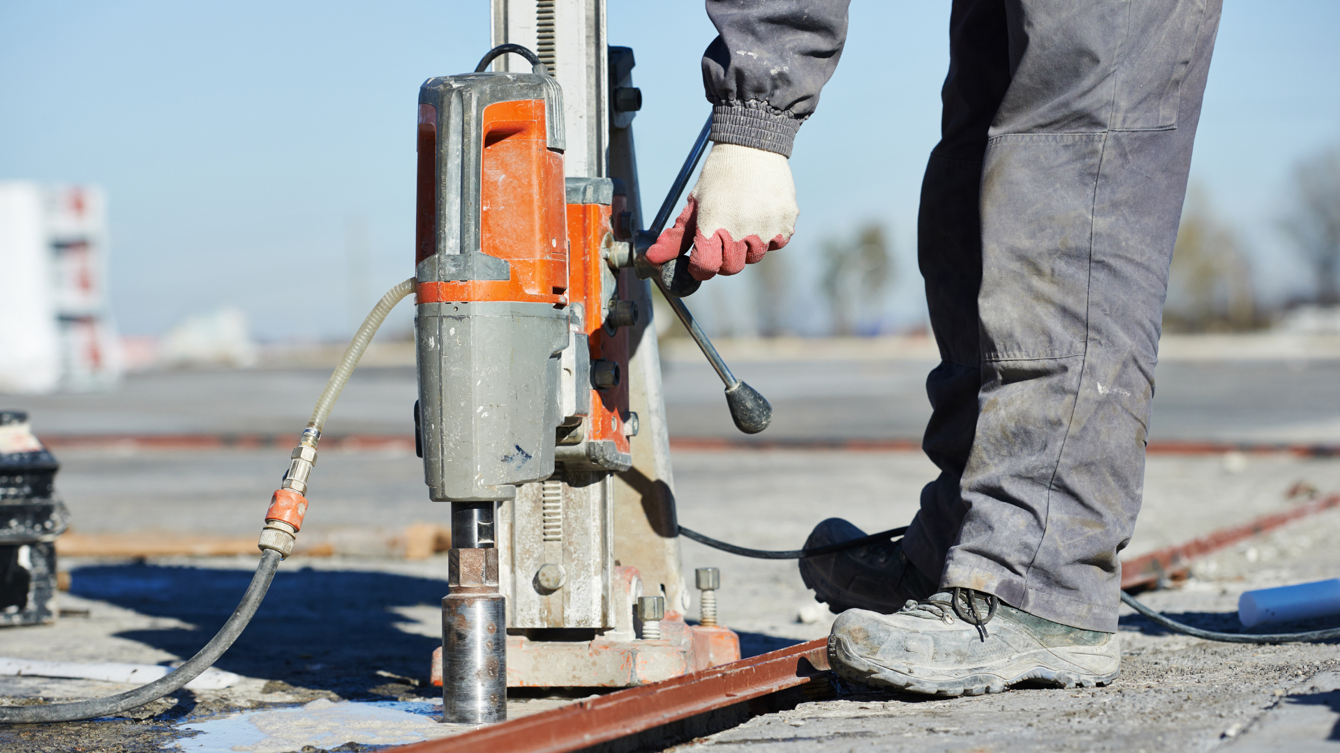 A construction worker is using a machine to drill a hole in the ground.