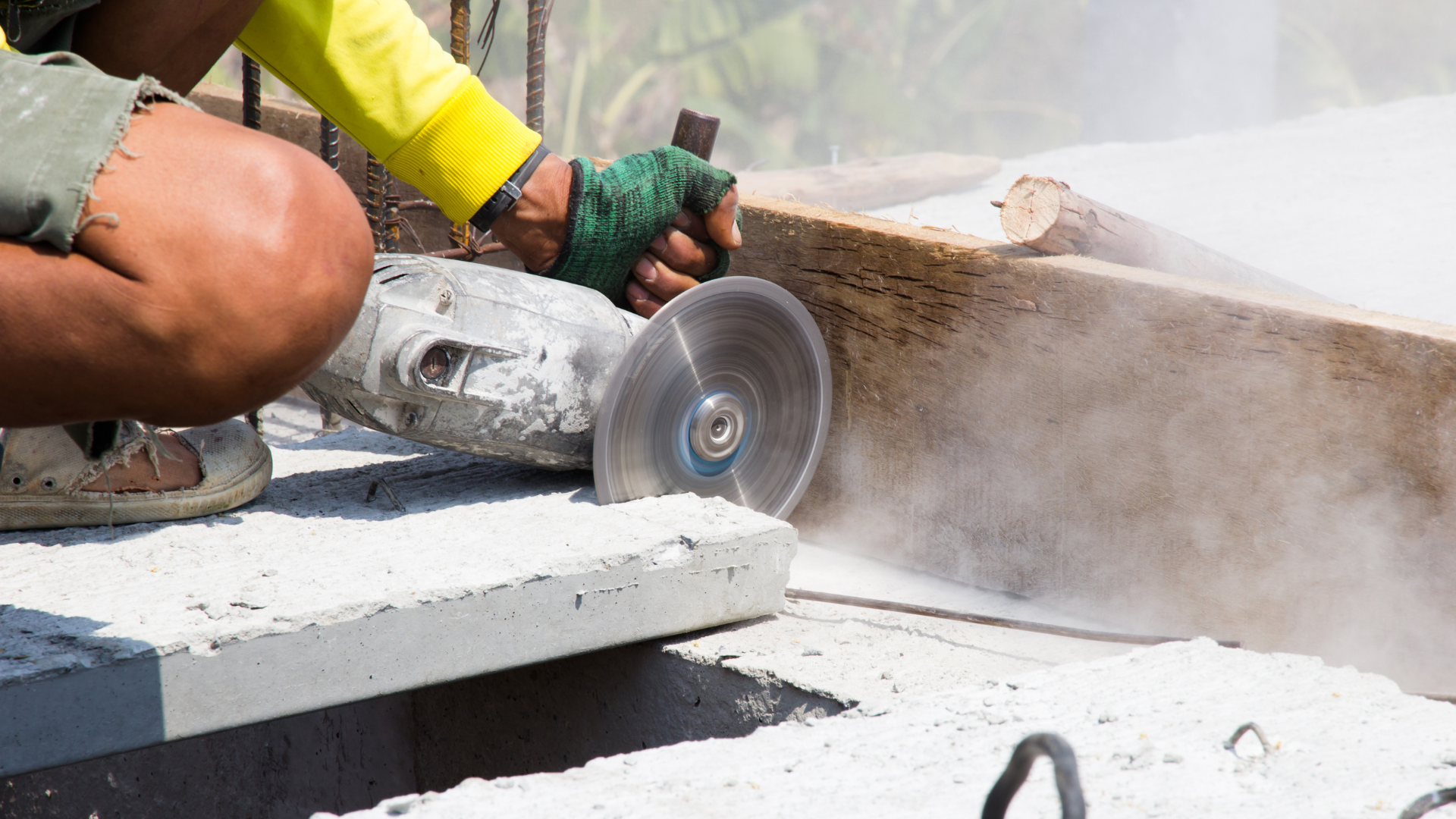 A man is cutting a piece of concrete with a grinder.